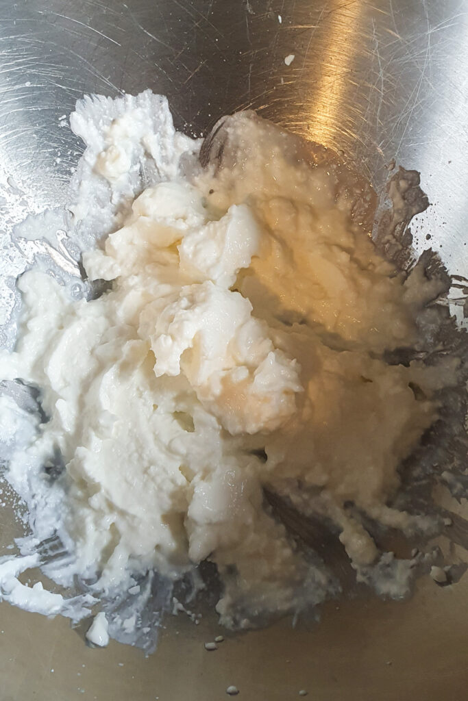 A close-up of whipped cottage cheese in a metallic bowl.
