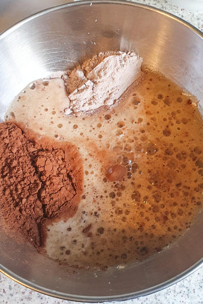 A mixing bowl brims with wet and dry ingredients for cottage cheese brownies.