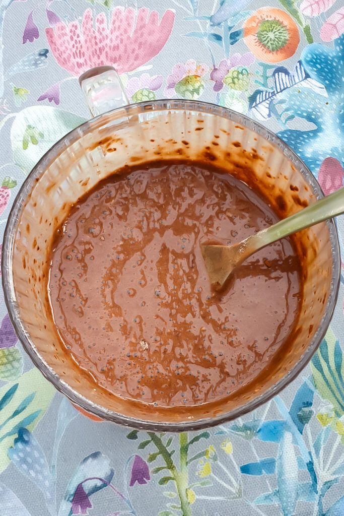 Chocolate protein mug cake batter in a mug with a fork.