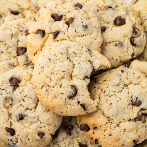 A pile of cottage cheese chocolate chip cookies, including one with a bite taken out.