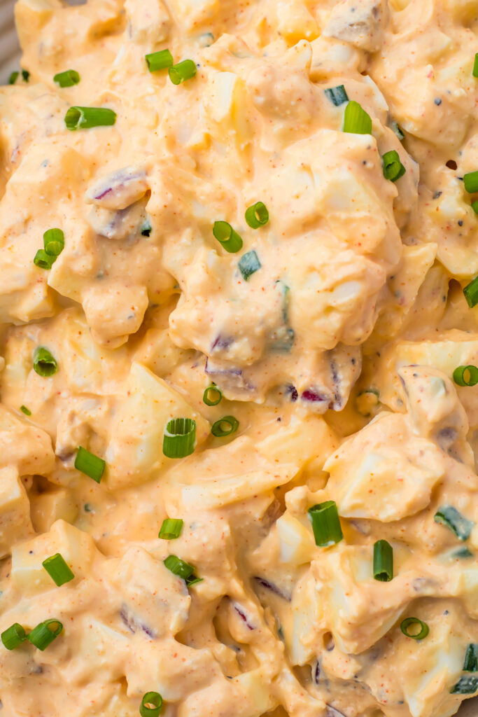 Close-up of creamy egg salad mixed with cottage cheese, chopped green onions, and spices—an irresistible egg salad recipe.