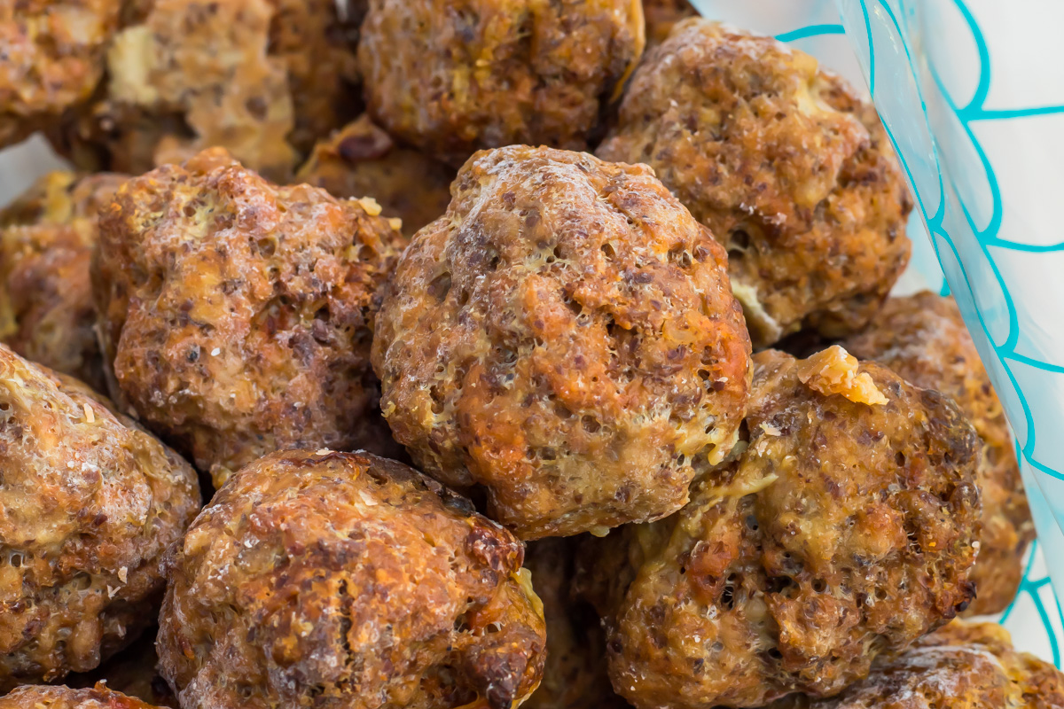 A close-up view of several cooked frozen meatballs in a ziplock bag.