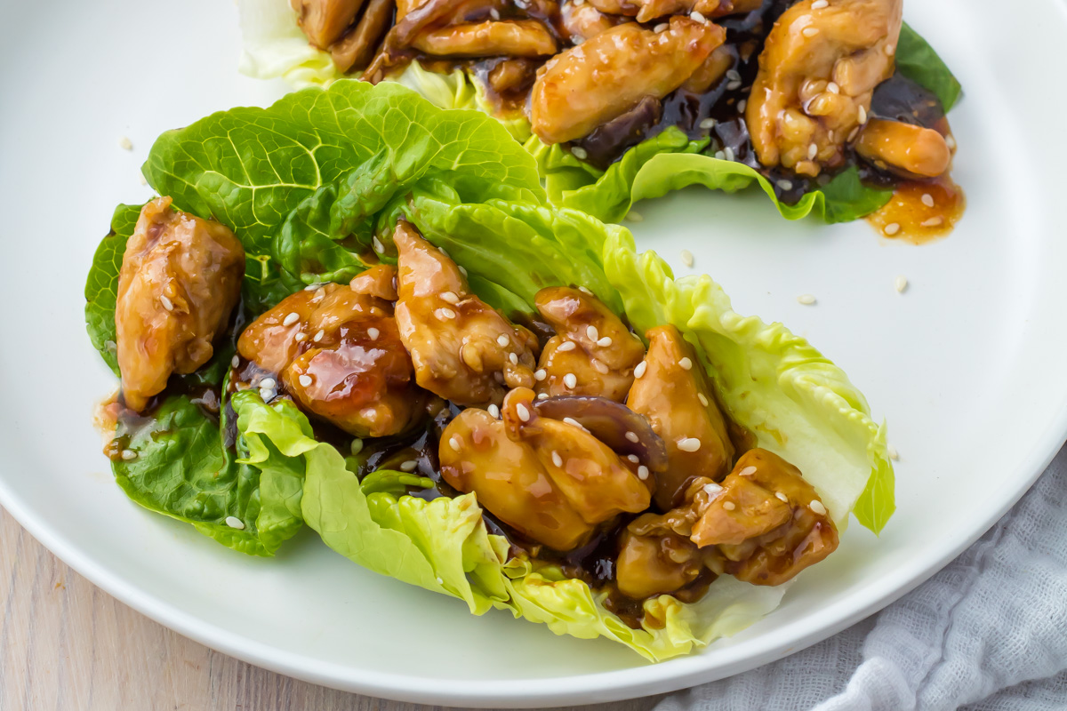 Teriyaki chicken lettuce wraps arranged on a white plate.