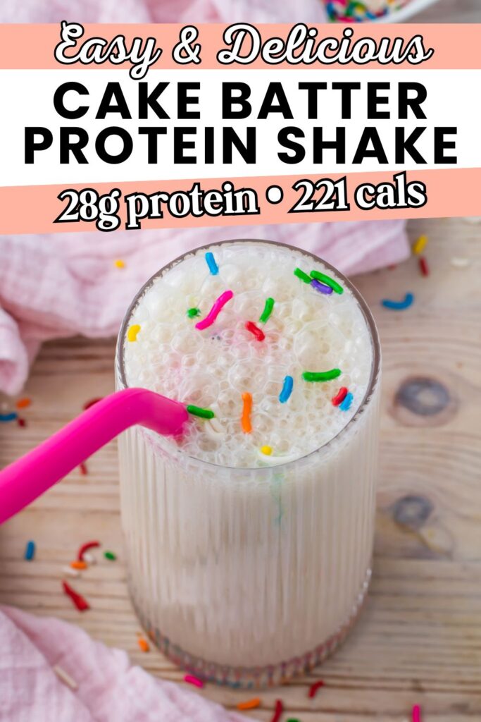 A delicious glass of cake batter protein shake with colorful sprinkles on top and a pink straw sits on a wooden surface, next to a soft pink cloth. The text overlay highlights the impressive protein and calorie content of this indulgent cake batter protein shake.